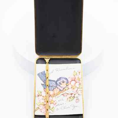 Card inside cigarette case: A card with a bird and flowers sits inside the cigarette case.