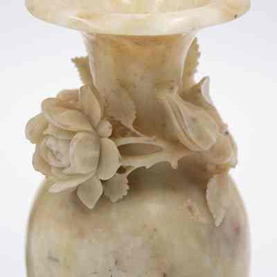 Cream soapstone vase: A cream soapstone vase is intricately adorned with delicate floral carvings elegantly decorating the surface.