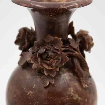 Brown soapstone vase: A brown soapstone vase is adorned with intricate flower carvings and subtle variations.