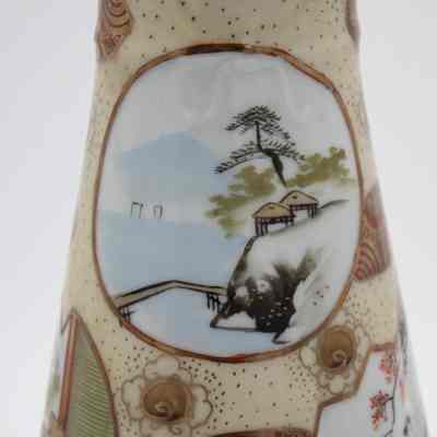 Painted Japanese porcelain teapot and lid scene.: Up close image of the gold and red painted teapot with matching lid. It is decorated with an image of of coastal scene and shows pagodas sitting by the water.