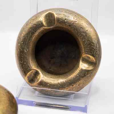 Ashtray: The image showcases a round brass ashtray with an intricate leaf design.