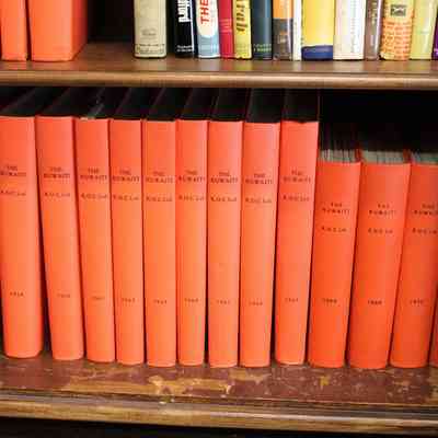 The Kuwaiti on the Bottom Shelf of the L.T. Jordan Collection: Image of the bottom shelf of "The Kuwaiti" on the bottom shelf of the L.T. Jordan's bookcase. The books are encased in an orange leather and have "The Kuwaiti", "K.O.C. Ltd." and each book's year on its spine.