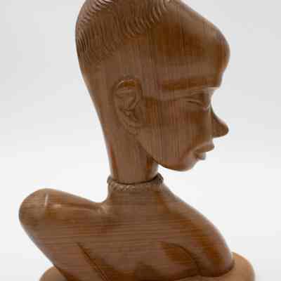 One of the carved wooden statuettes from Africa.: One of two matching carved wooden statuettes with twisted choker necklace. They are medium brown mahogany wood.