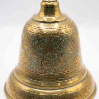 Brass dinner bell: The brass dinner bell has engraved leaves around the bell with blue enamel.