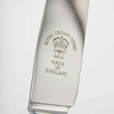 Blade of Royal Crown Derby knife.: Up close image of the silver blade of the Royal Crown Derby knives. It is engraved with their logo, "ROYAL CROWN DERBY MADE IN ENGLAND" and a small crown.