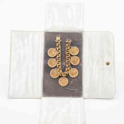 Gold Knit Chain Bracelet with Seven Gold Coins on Grey and White Case