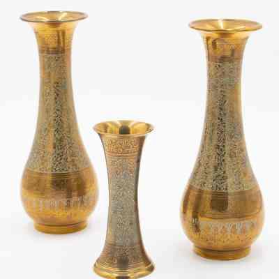 Brass vases: The image displays a trio of brass fluted vases adorned with intricate blue etched designs.