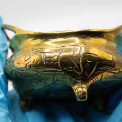 Chinese brass censer: A small, brass censer with engravings along the outside.