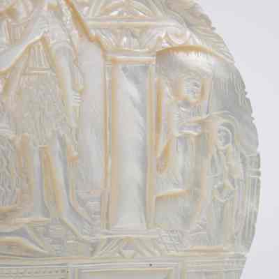 Bas relief: The bas relief plaque intricately depicts religious scenes using mother of pearl.