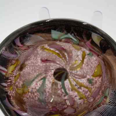 Glass ashtray: The image showcases a purple-blown glass ashtray adorned with vibrant, swirling patterns of colors.