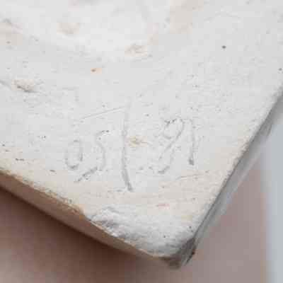 Back of the molded ceramic picture painted with Radha and Lord Krishna: Up close image of writing on the back of the molded ceramic picture. It reads "18 / 50."