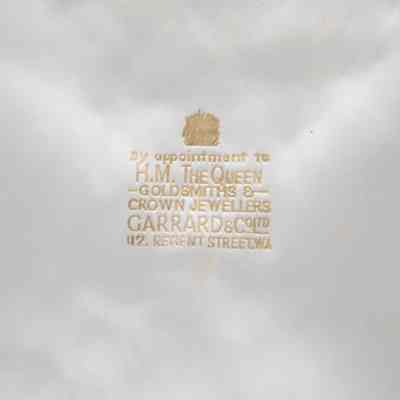 Label inside box: A gold label inside the white box, stating, "By appointment to H.M. The Queen; Goldsmiths & Crown Jewellers; Garrad & Co. Ltd. 112 Regent Street. WA."