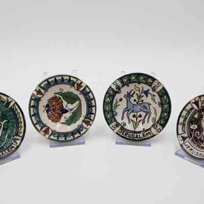 Set of four ceramic painted ashtrays given to the Jordans by a ruler in Bombay.: Image of the four ceramic painted ashtrays. Three of them are inscribed with "JERUSALEM" and all are painted with a similar color scheme of green, blue, orange, and purple. The motifs painted on the ashtrays are consistent with other folk art from the Middle East made during the mid-20th century.