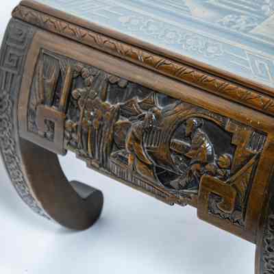Side and legs of coffee table: The image shows an intricately carved wood coffee table from Hong Kong with arched legs, featuring detailed artistic designs and traditional motifs.