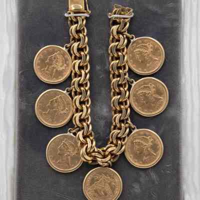 Coin bracelet: This image shows a gold knit chain bracelet adorned with seven 24k "Liberty Head" coins from 1885 to 1908.