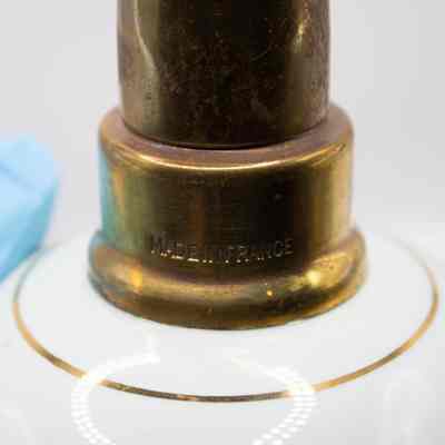 Close up of neck of blue Lampe Berger: The gold neck has a "MADE IN FRANCE" engravement.