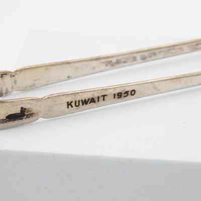Side of tongs: The side of the tongs has "Kuwait 1950," engraved into it.
