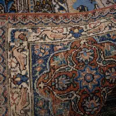 Large cream and blue area rug with deer: The rug features intricate cream and blue patterns, including stylized deer motifs, and has fringe.