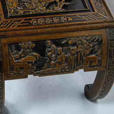 Side of coffee table: The carved wood coffee table features intricate details and elegantly arched legs.
