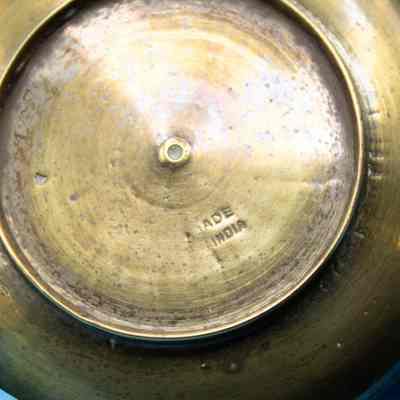 Bottom of ashtray: The image shows the bottom of a round brass ashtray, labeled "Made in India."
