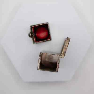 Silver Italian lipstick box gifted to Mrs. Jessie Jordan by the queen consort of Iran.: Top down image of the inside of the silver Italian lipstick box. The lipstick inside is bright red.