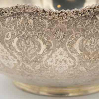 Medium-sized silver bowl: The bowl features intricate etchings and a scalloped edge.