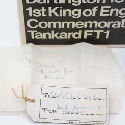 Note and tissue paper found associated with the tankard.: Up close image of the notes with the tankard. The card reads "To: Mr. + Mrs. L.T. Jordan" and "From: Jack, Nadine, + Deirdre." The tissue paper reads "To Jessie with love from Deirdre."
