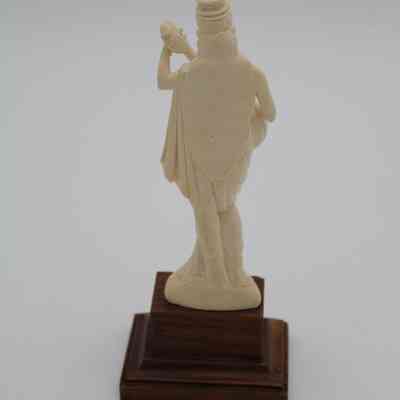 Back of woman figurine: The back of the figurine shows the woman's long hair and loose dress.