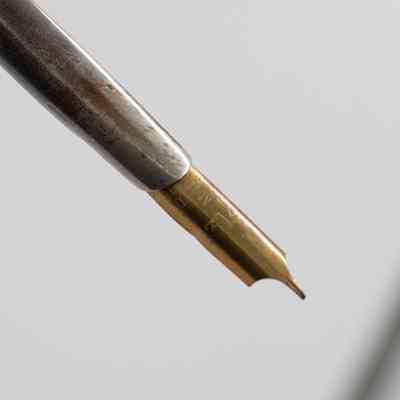 Pen nib: The image showcases a gold metallic pen nib attached to a silver holder.