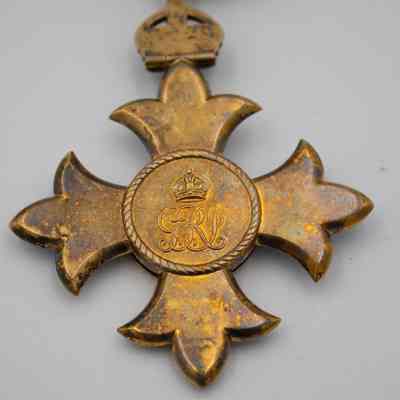 Back of Commander of the British Empire medal: The back of the medal is fully gold-plated silver with a crown logo above three initials.