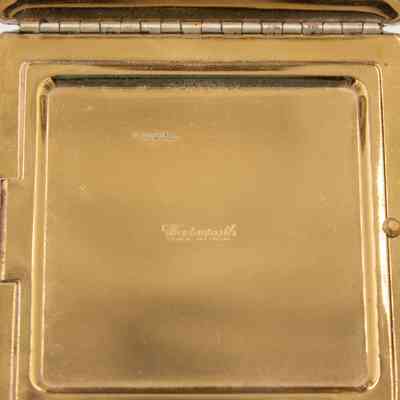 Inside of compact: The inside of the compact has a gold opening and closing cover.