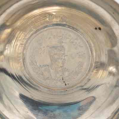 Small silver coin bowl with the a coin of Shah Reza Pahlavi. Pahlavi was the Shah of Persia from 1925-1941.: Up close image of the coin inside the silver coin bowl depicting Shah Reza Pahlavi of Persia.