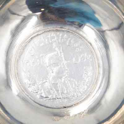 Small silver coin bowl with a coin of Shah Reza Pahlavi. Pahlavi was the Shah of Persia from 1925-1941.: Up close image of the coin inside the silver coin bowl depicting Shah Reza Pahlavi of Persia.