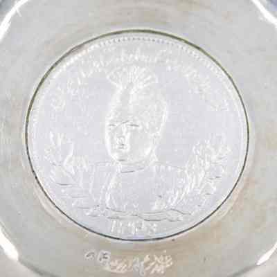 Small silver coin bowl with a coin of Shah Ahmad Qajar. Qajar was the Shah of Persia from 1909-1925 and was the last ruling member of the Qajar dynasty.: Up close image of the coin inside the silver coin bowl depicting Shah Ahmad Qajar of Persia.