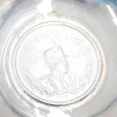 Small silver coin bowl with the a coin of Shah Reza Pahlavi. Pahlavi was the Shah of Persia from 1925-1941.: Up close image of the coin inside the silver coin bowl depicting Shah Reza Pahlavi of Persia.
