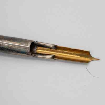 Pen nib: The image showcases a gold metallic pen nib attached to a silver holder.