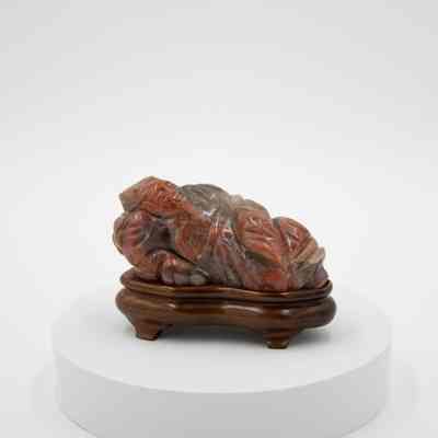 Carved Red and Grey Soapstone Figurine of Reclining Man on Wooden Base