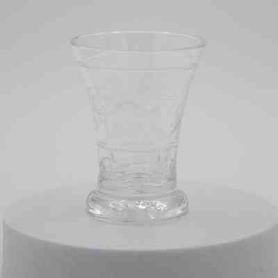 Small glass: A clear glass is delicately etched with intricate floral designs on its surface.