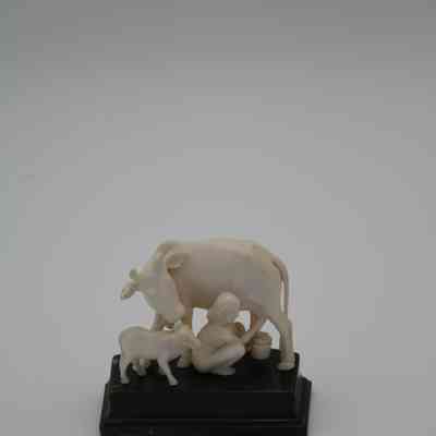 Carved Ivory Figurine of Child Milking a Cow on a Wooden Base