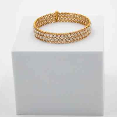 One of Jessie Jordan's gold and pearl bracelets.: Up close image of the gold and pearl bracelet with two "channels" of pearls around bracelet.