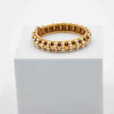 One of Jessie Jordan's gold and pearl bracelets.: Up close image of the gold and pearl bracelet with multiple rows of pearls set across the band.