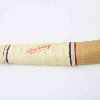 Field hockey stick bow: White wrapping around the head has red, white and blue thin stripes around a "Spalding" logo.