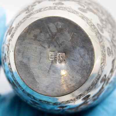 Base of urn: The base of the urn has illegible engravings.