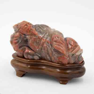 Carved soapstone figurine from China.: Up close image of the carved soapstone figurine of reclining Chinese man on a mahogany wood base.