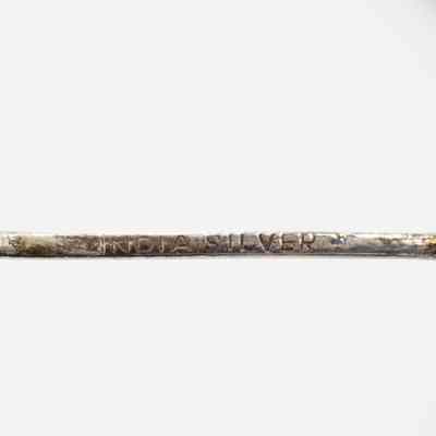 Back of one of the coffee spoons.: Up close image of the stamp on the back of one of the silver coffee spoons. The stamp reads "INDIA SILVER."