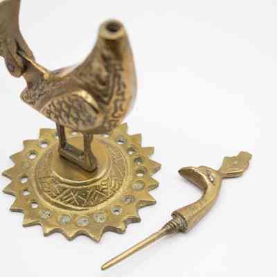 Peacock eyeliner holder, head removed: The head has been taken off the eyeliner holder, showing the well in the body and the applicator on the head.