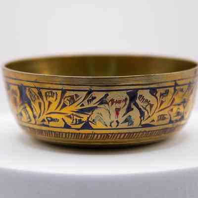 Brass finger bowl with blue and red enameled leaf design: A small bowl with etched in flowers that are colored with red and blue enamel.