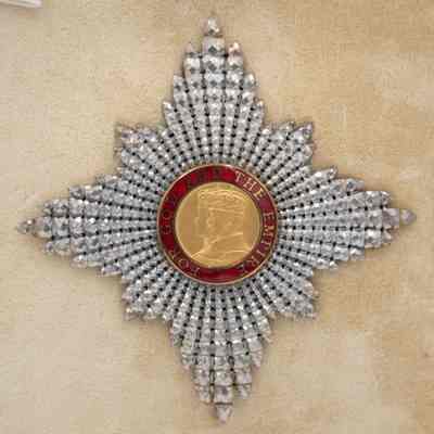 Knight of British Empire medal: The image shows a star-shaped medal awarded to Mr. Jordan in 1958, featuring a detailed, ornate design with a golden central portrait surrounded by a red inscription, "For God and The Empire."