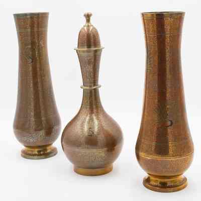 Peacock vases: The image displays two tall brass vases flanking an ornately designed brass bottle.