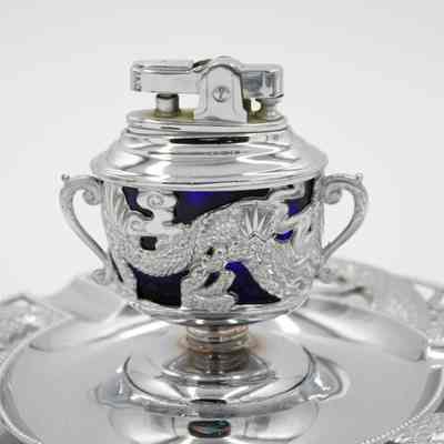 Silver and cobalt glass lighter from Persia.: Up close image of the silver and blue cobalt glass ashtray and lighter. Both are decorated with dragon motifs.